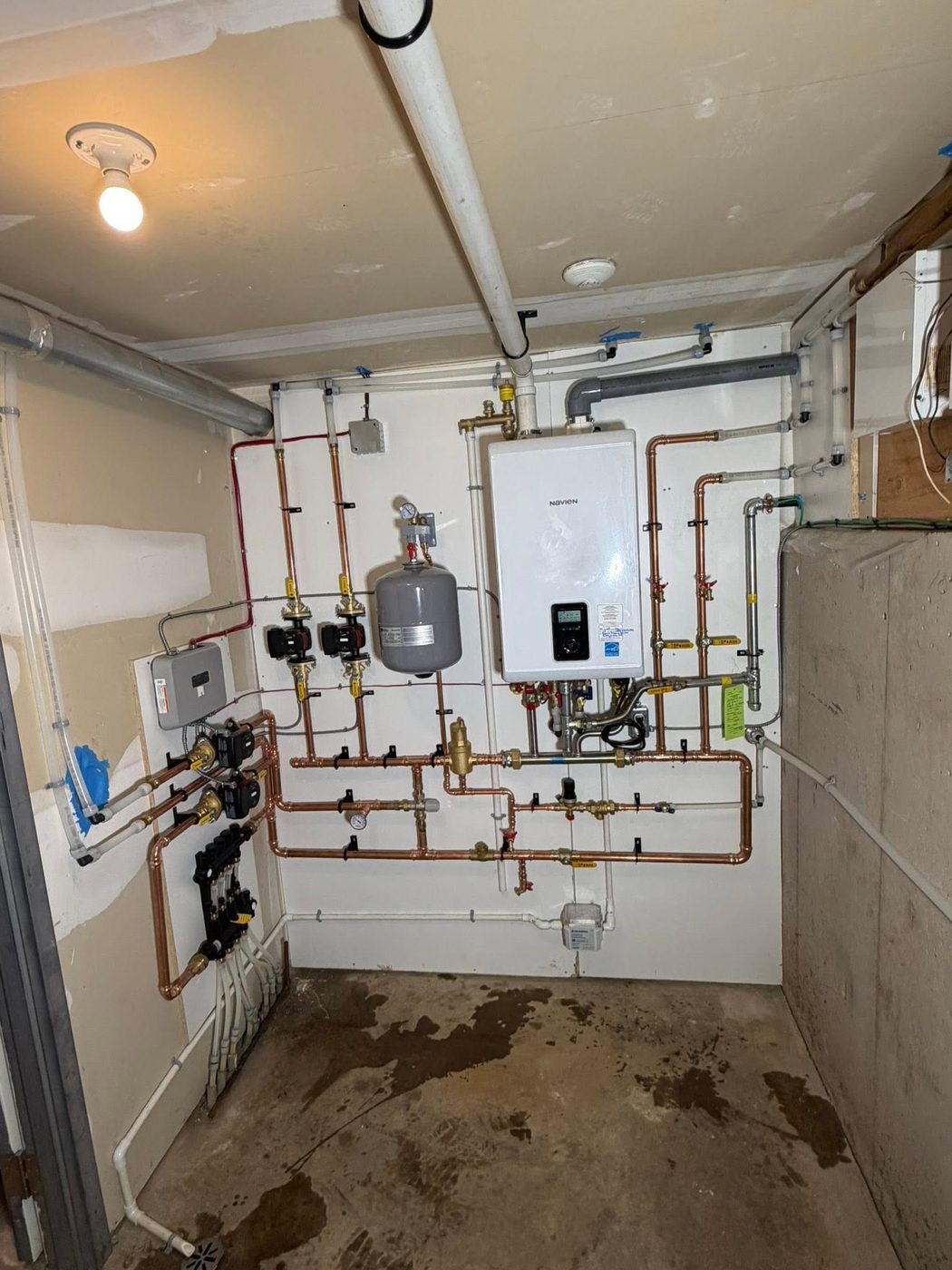 Wall-hung condensing boiler with four circulators, expansion tank and new copper piping replacing the old oil boiler
